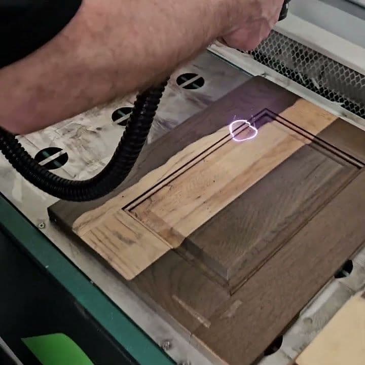 Handwerker graviert mit einem Laser ein Muster in Holz
